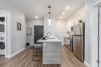 A modern kitchen with stainless steel appliances and a wooden island.